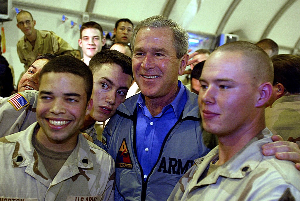 US President George W Bush poses with soldiers during a surprise Thanksgiving day visit with US troops stationed at Baghdad International Airport 27 November 2003 (AFP)
