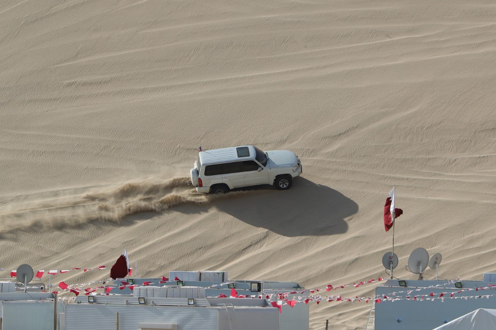 Un 4x4 roule sur une dune du désert de Sealine au Qatar, à environ 63 kilomètres au sud de la capitale Doha, le 8 janvier 2021 (AFP)