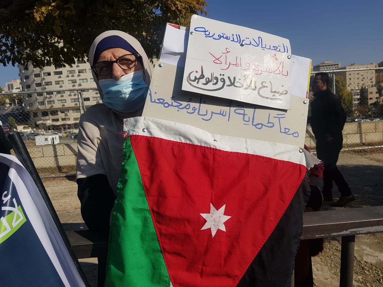 A women protesting for women's rights outside Jordan's parliament (MEE/Mohammad Ersan)
