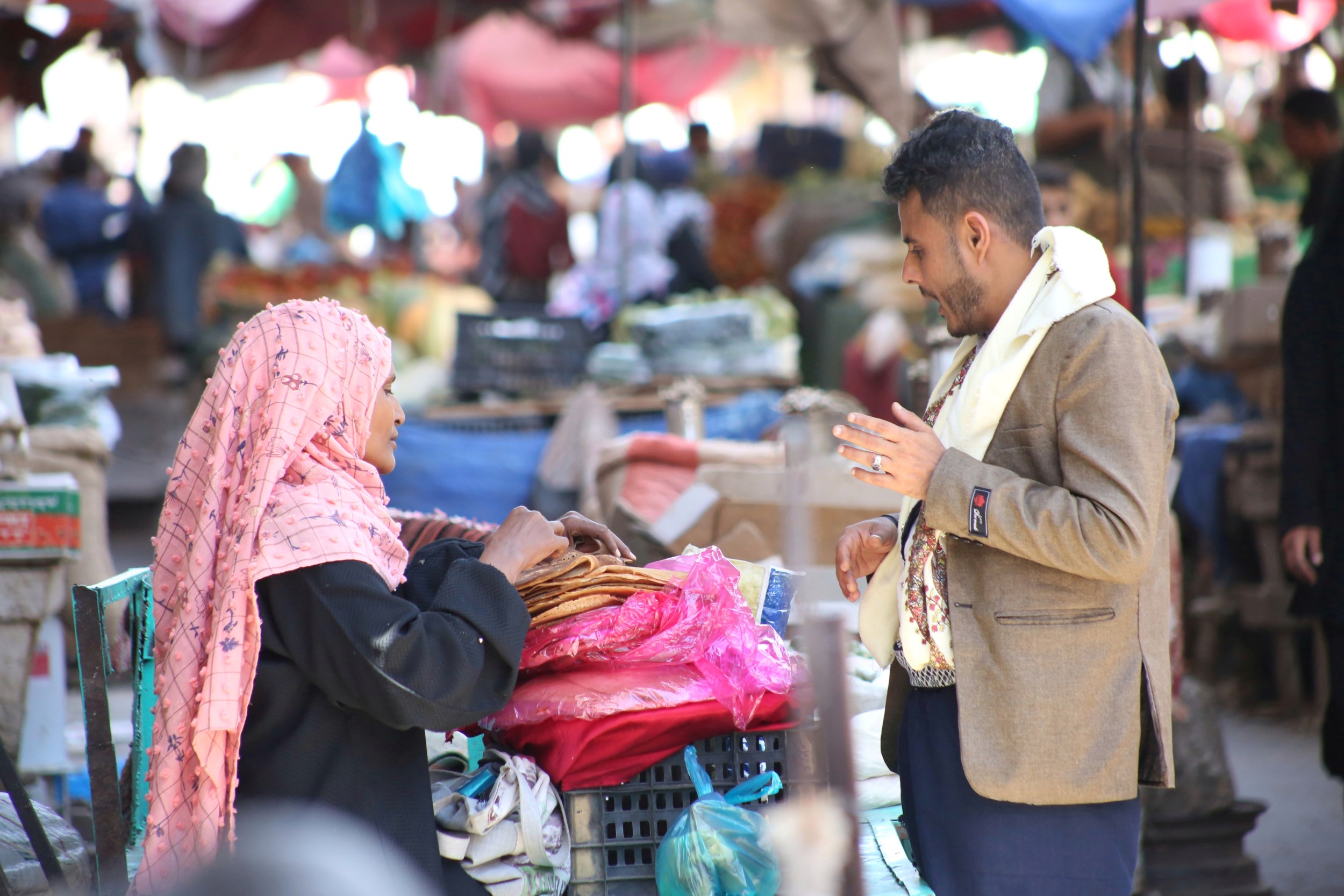 A merchant sells lahooh - a spongy flatbread which is a staple of iftar in Yemen - in a Taiz market on 25 April 2020 (MEE/Khalid Al-Banna)