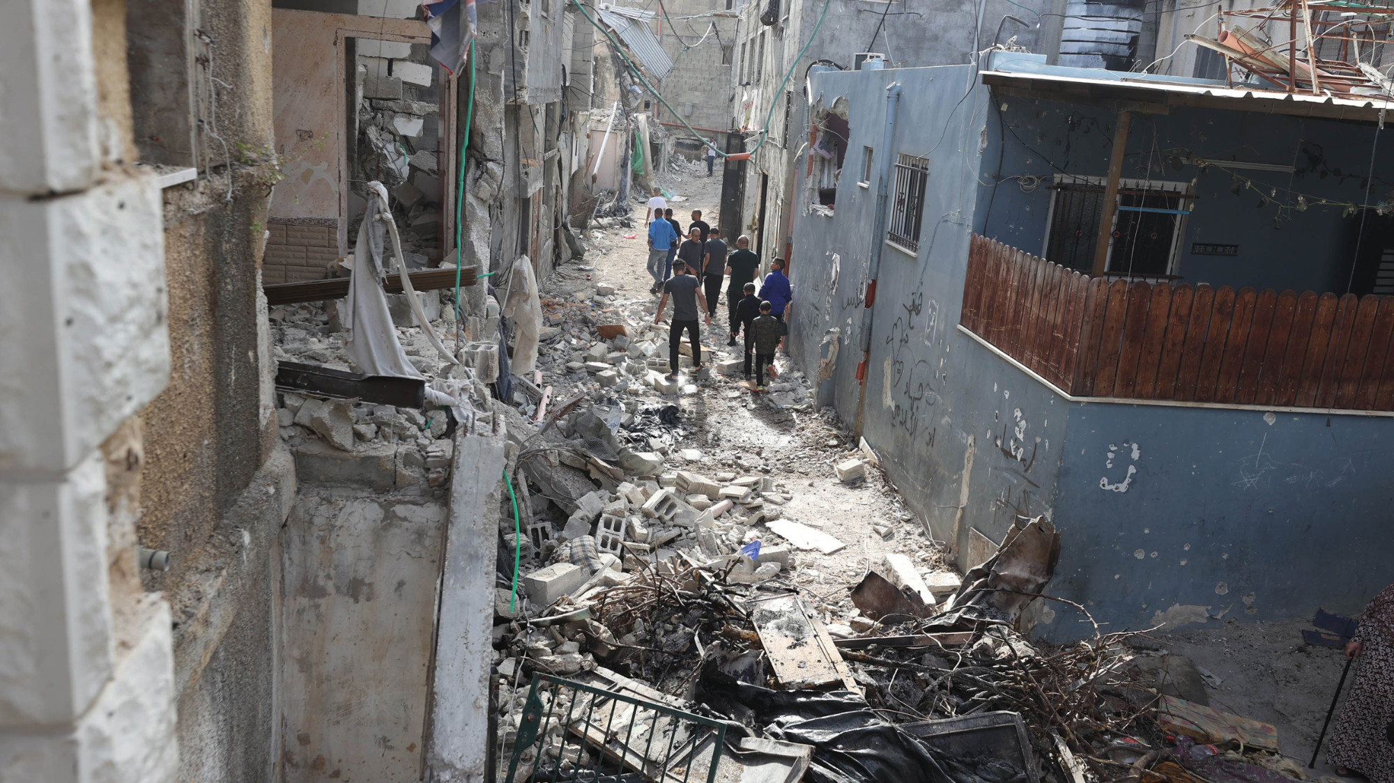 Palestinos caminan entre los escombros de casas destruidas por las fuerzas israelíes en Tulkarm, en la Cisjordania ocupada, 21 de abril de 2024 (MEE/Muhammad Ateeq)