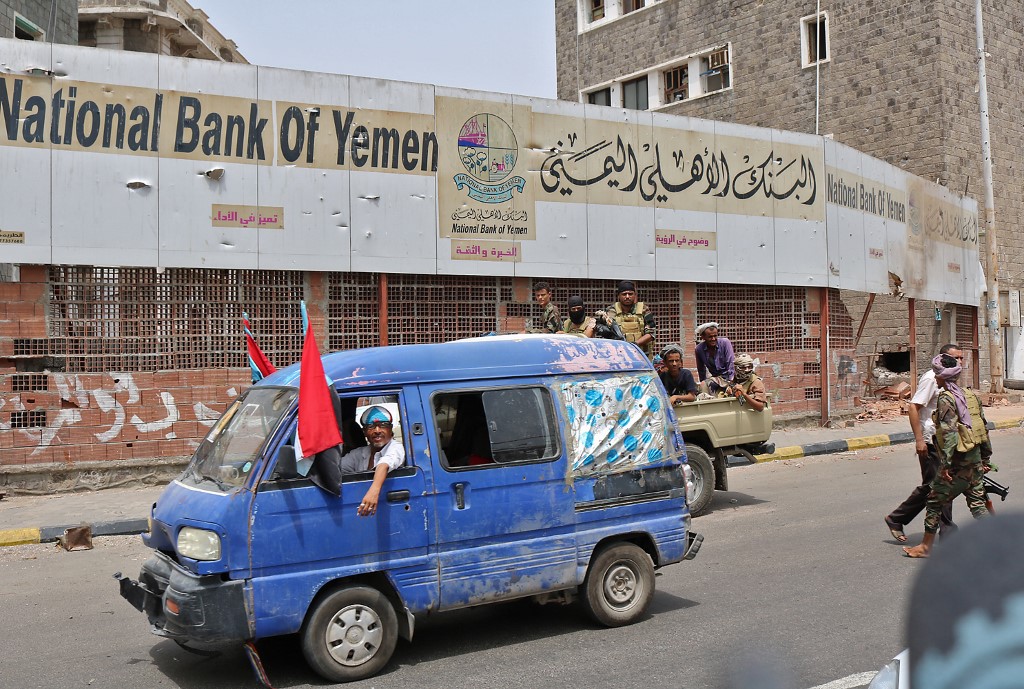 A man flies the southern Yemeni separatist flag, driving around Aden this week (AFP)