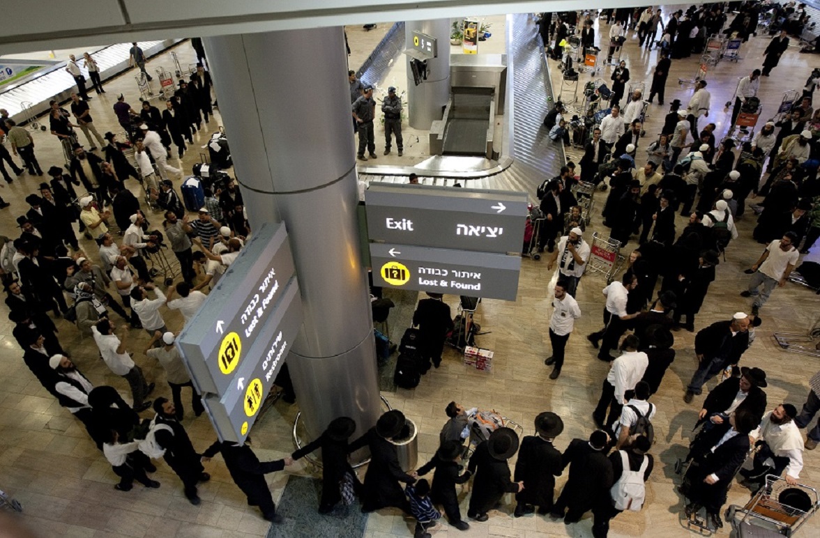 Des passagers, dont un groupe de juifs ultra-orthodoxes revenant de pèlerinage en Ukraine, attendent leurs bagages dans le hall des arrivées de l’aéroport international Ben Gourion le 13 septembre 2010 (AFP)