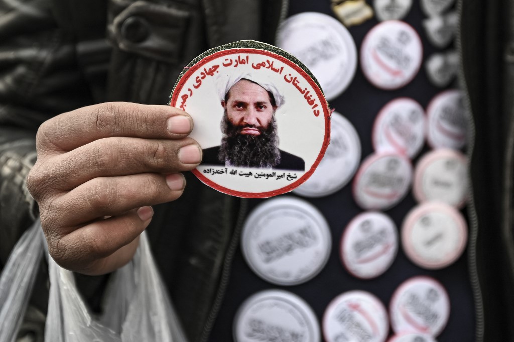 A man sells stickers picturing Taliban leader Hibatullah Akhundzada in Kabul on 26 December 2021 (AFP)