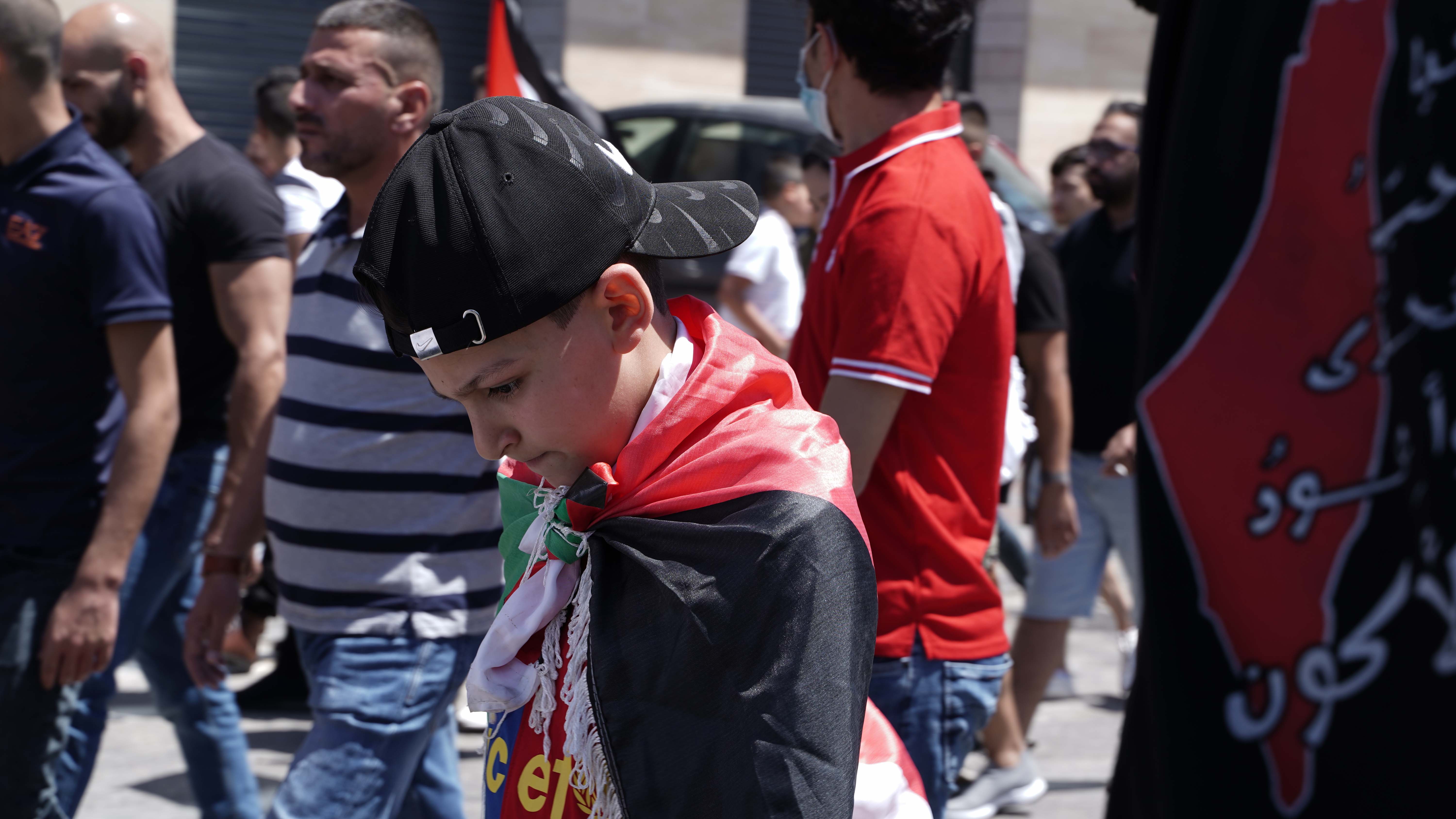 A young boy looks down during a protest in Bethlehem (MEE/Akram al-Waara)