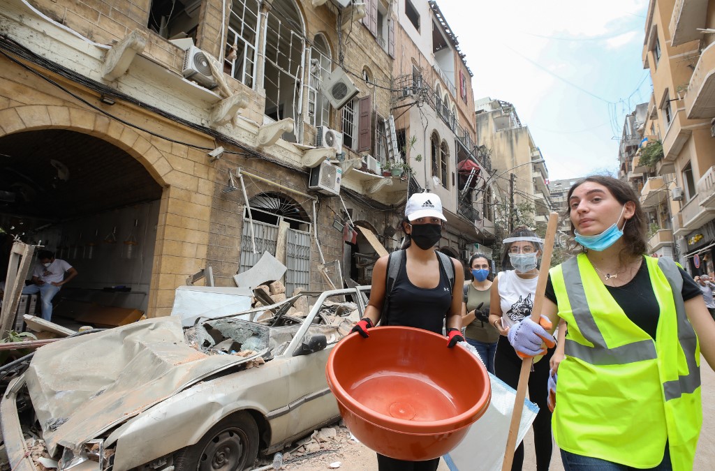 Des bénévoles arrivent dans le quartier de Gemmayzeh à Beyrouth pour déblayer les décombres, le 6 août (AFP)