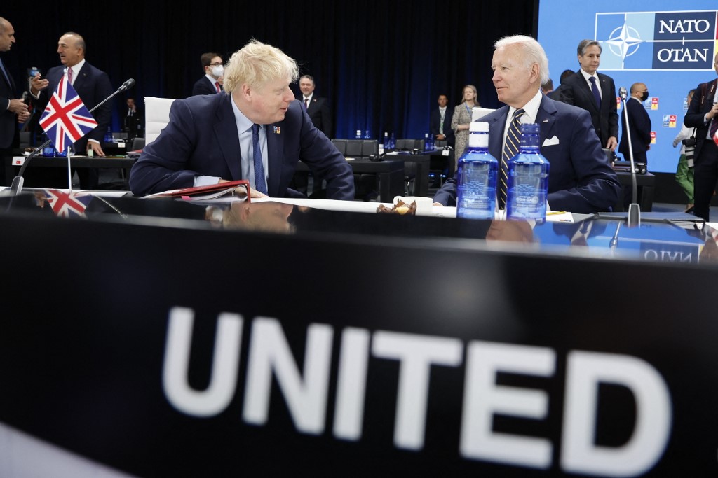 US President Joe Biden and British Prime Minister Boris Johnson speak at the Nato summit in Madrid on 30 June 2022 (AFP)