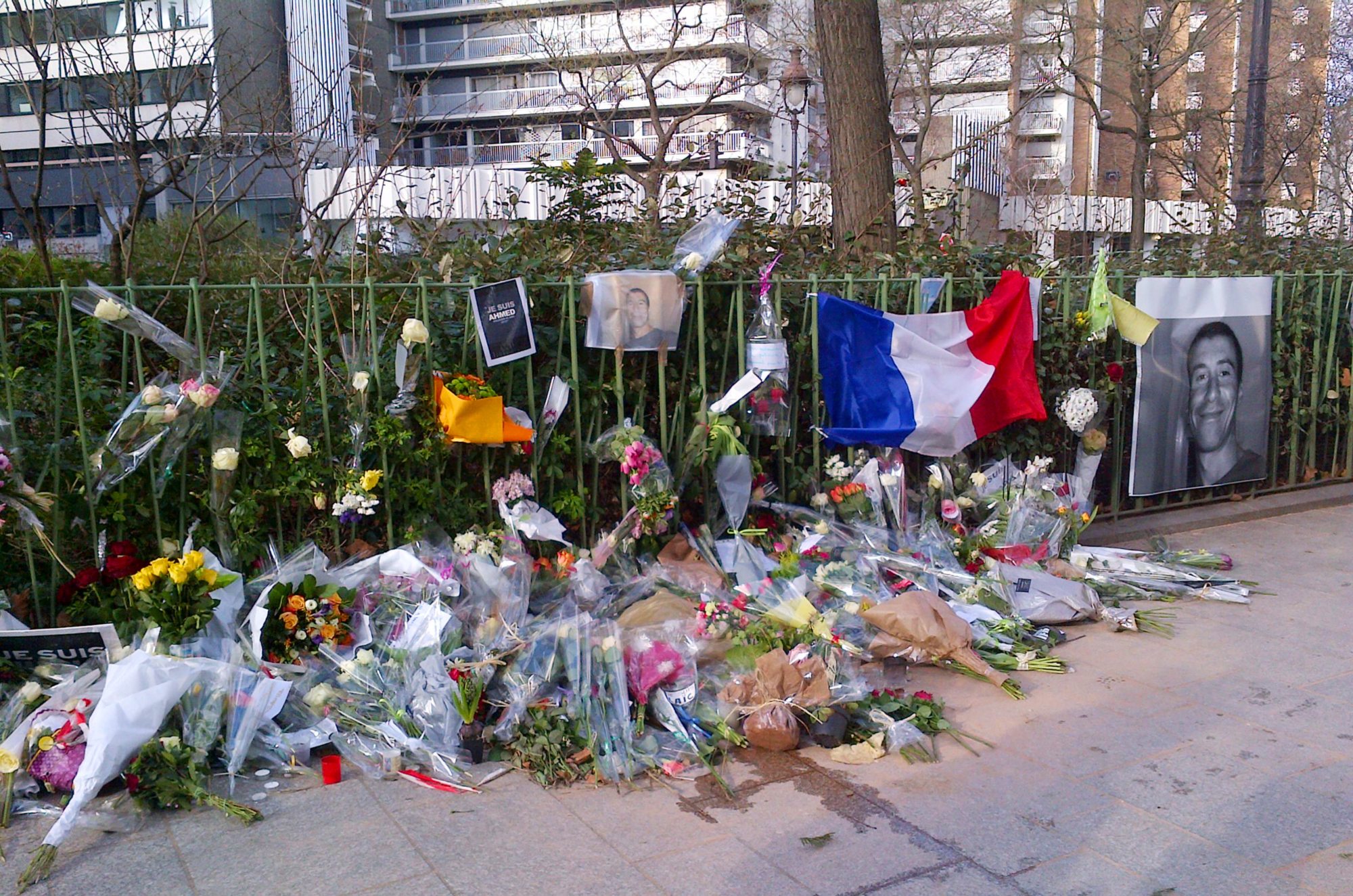 A portrait of Ahmed Merabet, the French policeman killed during the attack on Charlie Hebdo Magazine, is displayed with flowers and other tributes on 11 January 2015 in Paris (AFP)