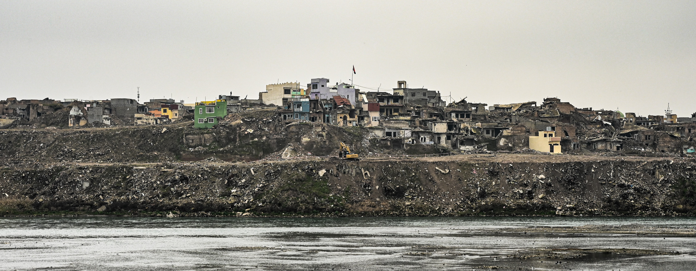 General view of the destroyed old city of Mosul from across the Tigris. A few families have returned to live amongst the rubble (MEE/Finbar Anderson)