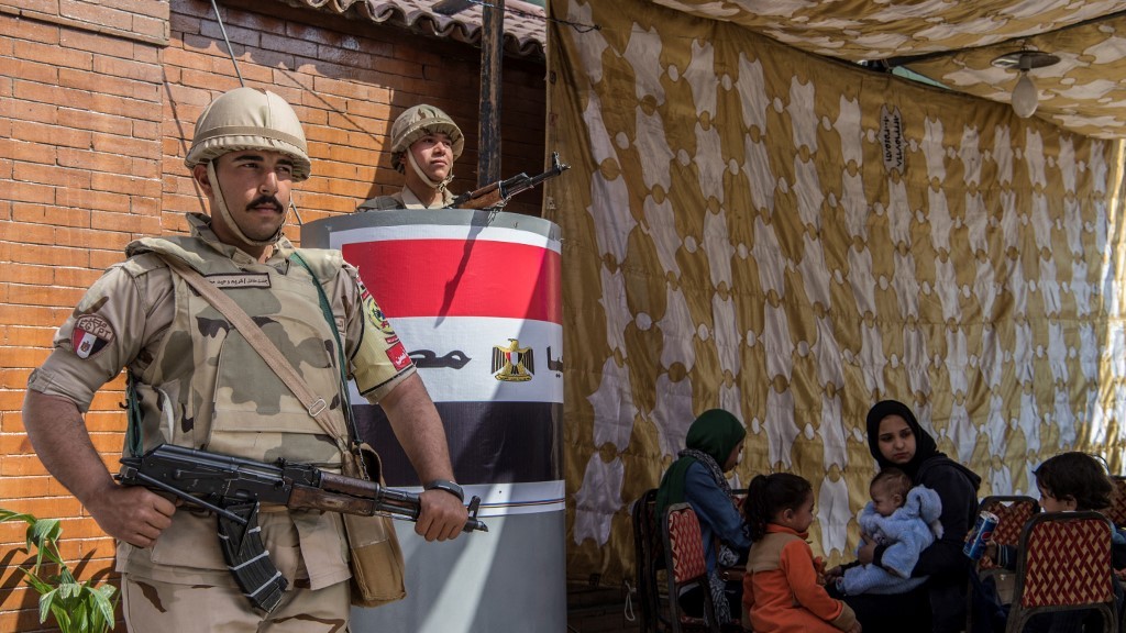 Egyptian soldiers stand guard outside a polling station during a referendum on constitutional amendments in Cairo on 22 April 2019 (AFP)