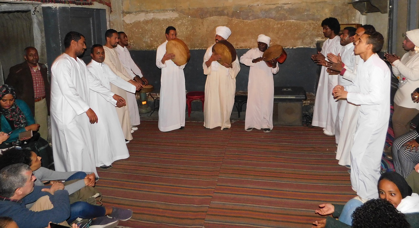 Farah El-Masry sings while tapping the duff with his group while others dance or clap their hands (MEE/Marwa al-Asar)