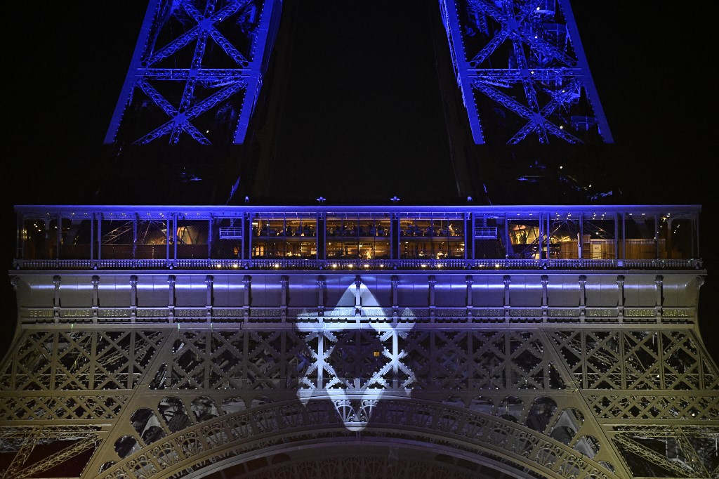 La Tour Eiffel à Paris illuminée aux couleurs du drapeau israélien et arborant l’étoile de David en hommage aux victimes de l’offensive du Hamas, le 9 octobre 2023 (AFP/Julien de Rose)