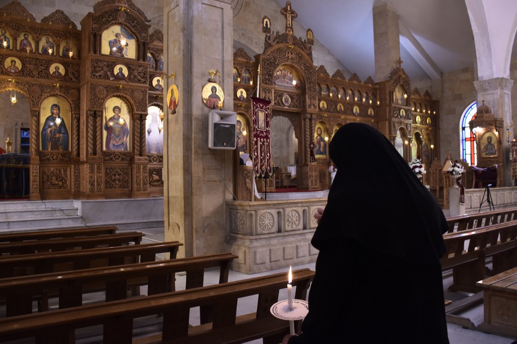 A nun attends mass at a Greek Orthodox church in Aleppo, Syria, on 19 April (AFP)