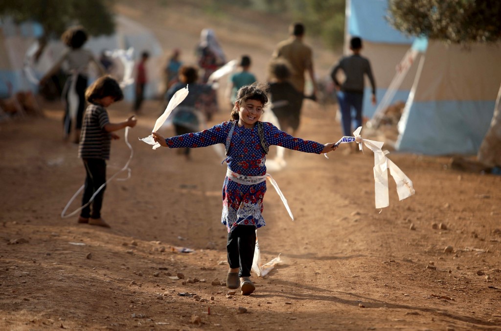 Syrian children play in a camp for displaced people near the Turkish border on 3 June (AFP)