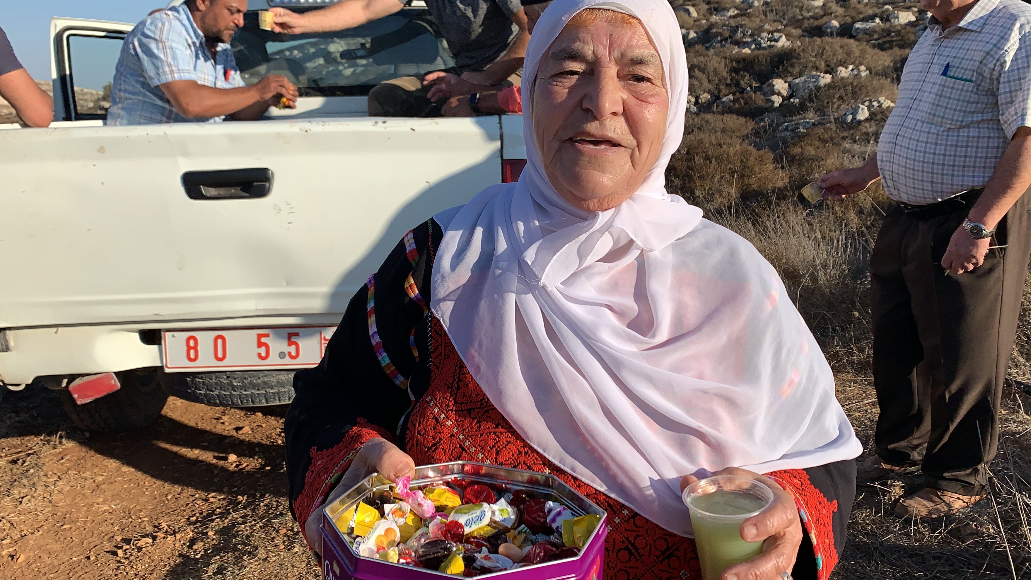 Mariam Hassan Hammad distribue des bonbons pour célébrer son arrivée à la limite de sa terre, près de 30 ans après que les Israéliens s’en sont emparés (MEE/Shatha Hammad)
