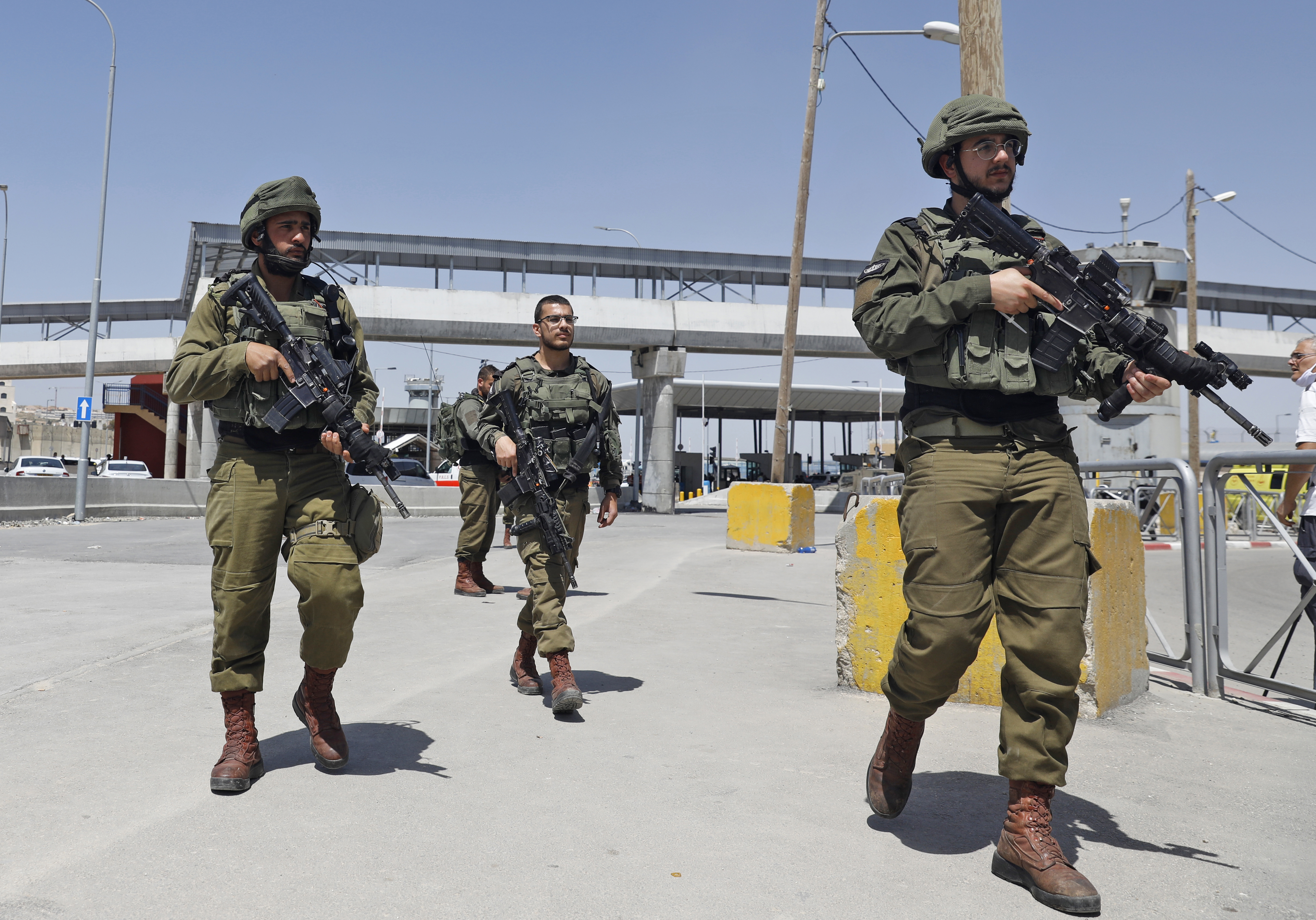 Des soldats israéliens se rassemblent au checkpoint de Qalandiya en Cisjordanie occupée le 12 mai (AFP)