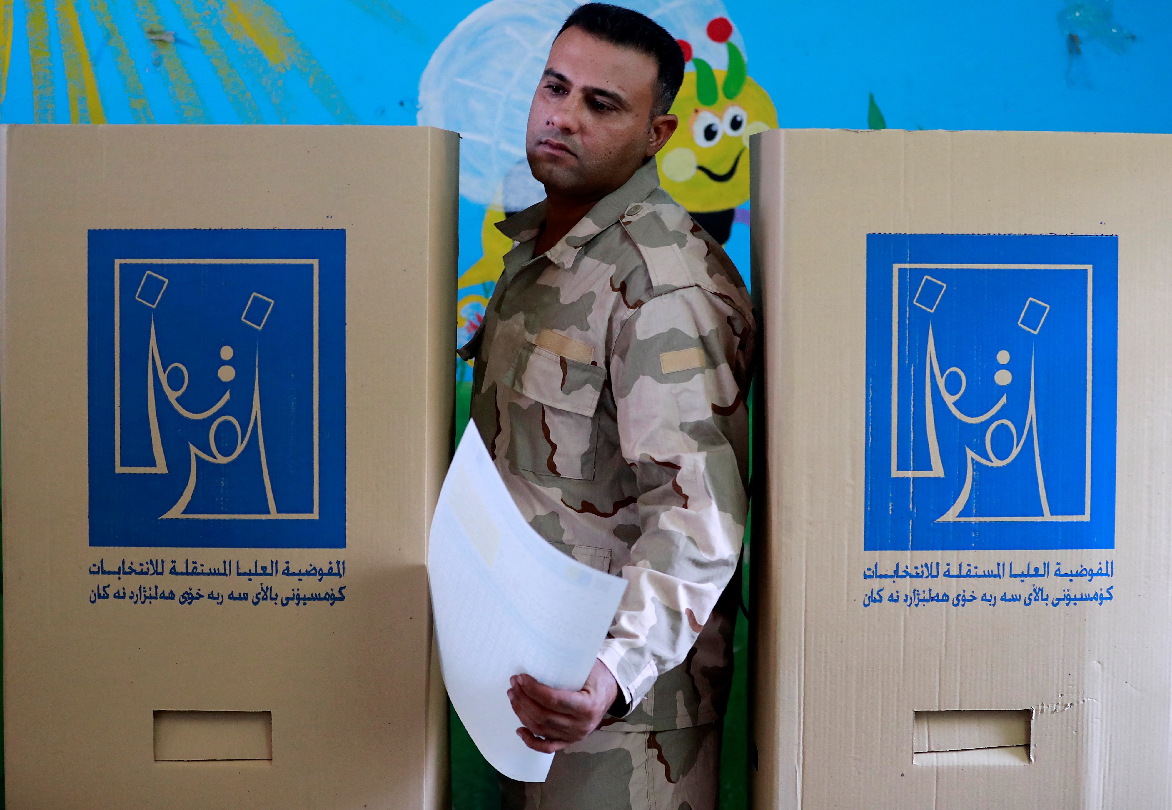 A member of Iraq's security forces participates in early voting in the capital Baghdad, 8 October 2021 (AFP)