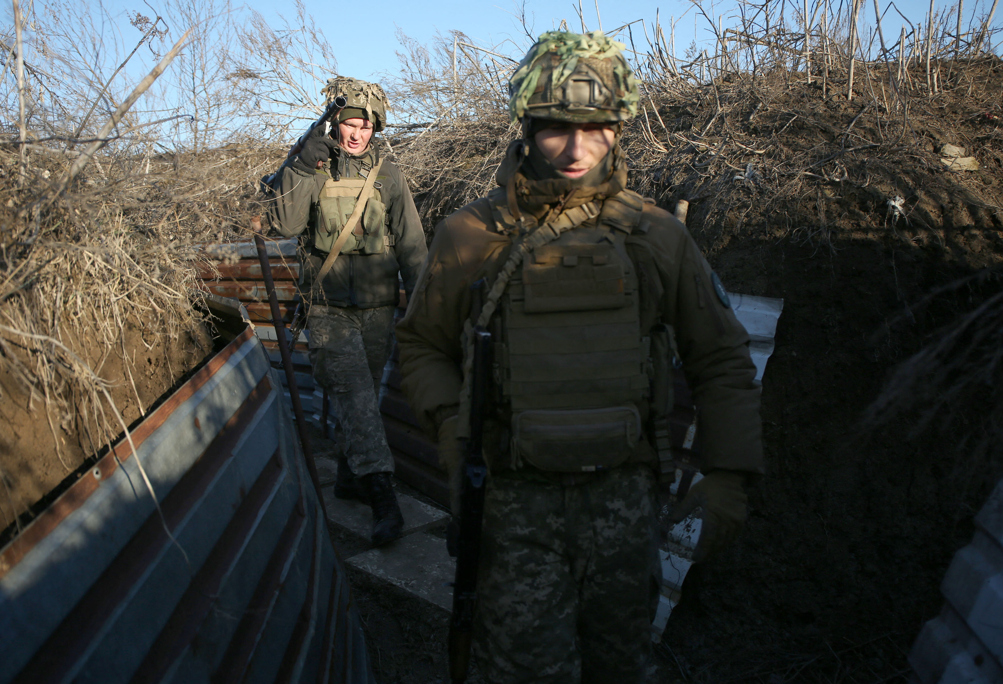 Ukrainian servicemen walk on a trench on the frontline with Russia-backed separatists near to Avdiivka, southeastern Ukraine, on 8 January 2022 (AFP)