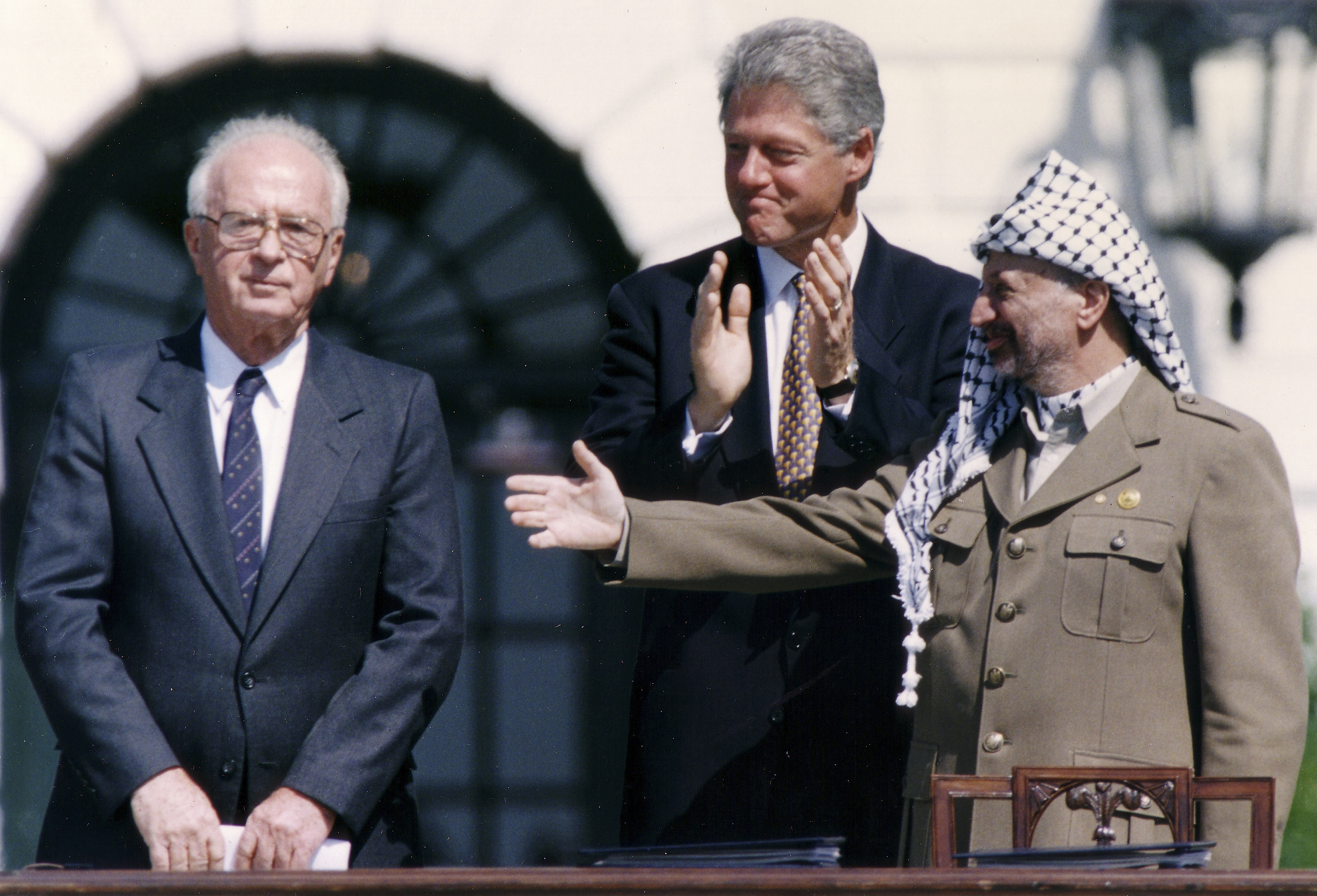 US President Bill Clinton stands between PLO leader Yasser Arafat and Israeli Prime Minister Yitzhak Rabin as they shake hands in September 1993 in Washington after signing the first Oslo accord (AFP)
