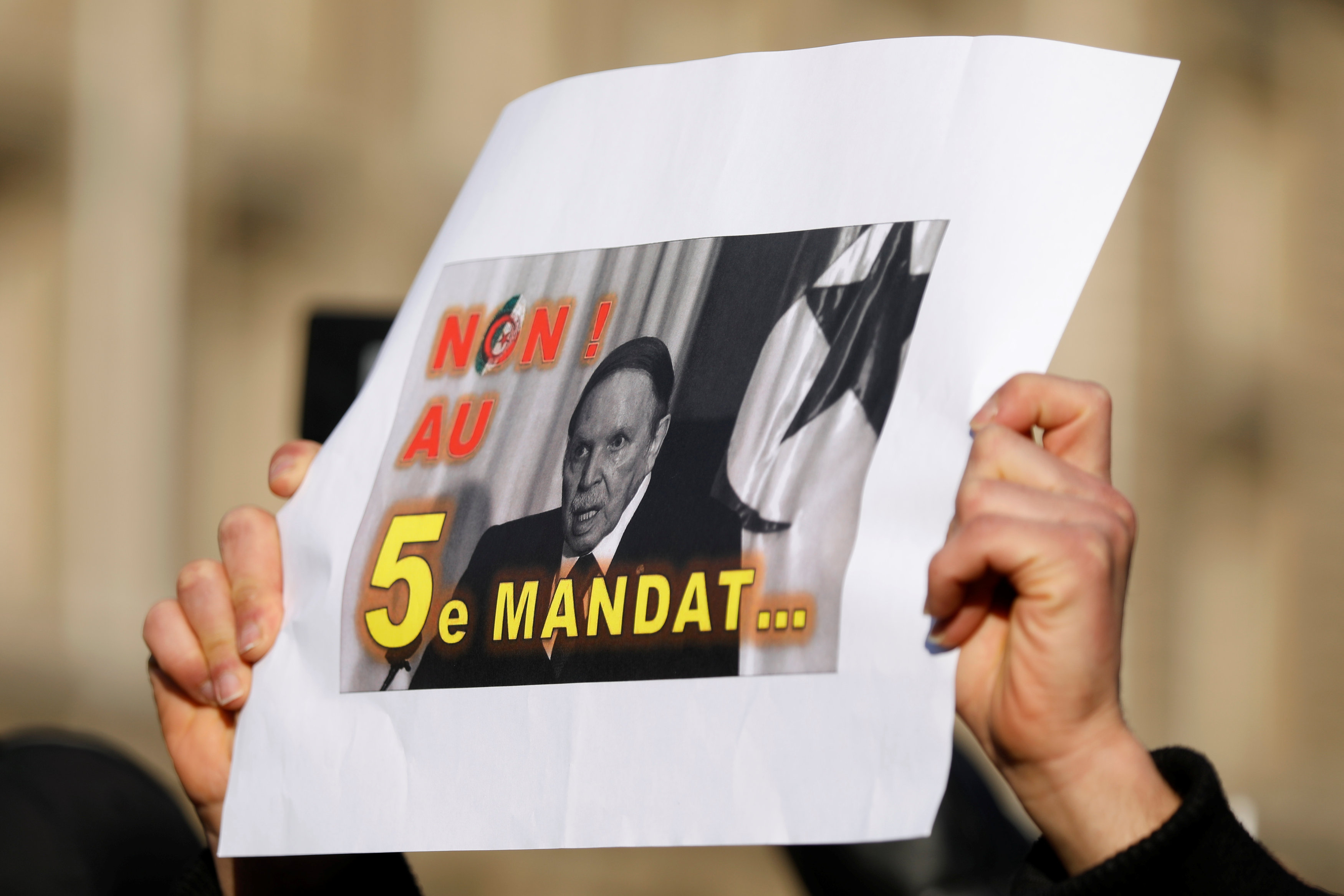 A demonstrator holds up a placard during a protest against President Abdelaziz Bouteflika seeking a fifth term (Reuters)