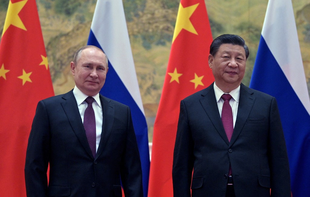 Russian President Vladimir Putin (L) and Chinese President Xi Jinping pose for a photograph during their meeting in Beijing, on 4 February 2022 (AFP)