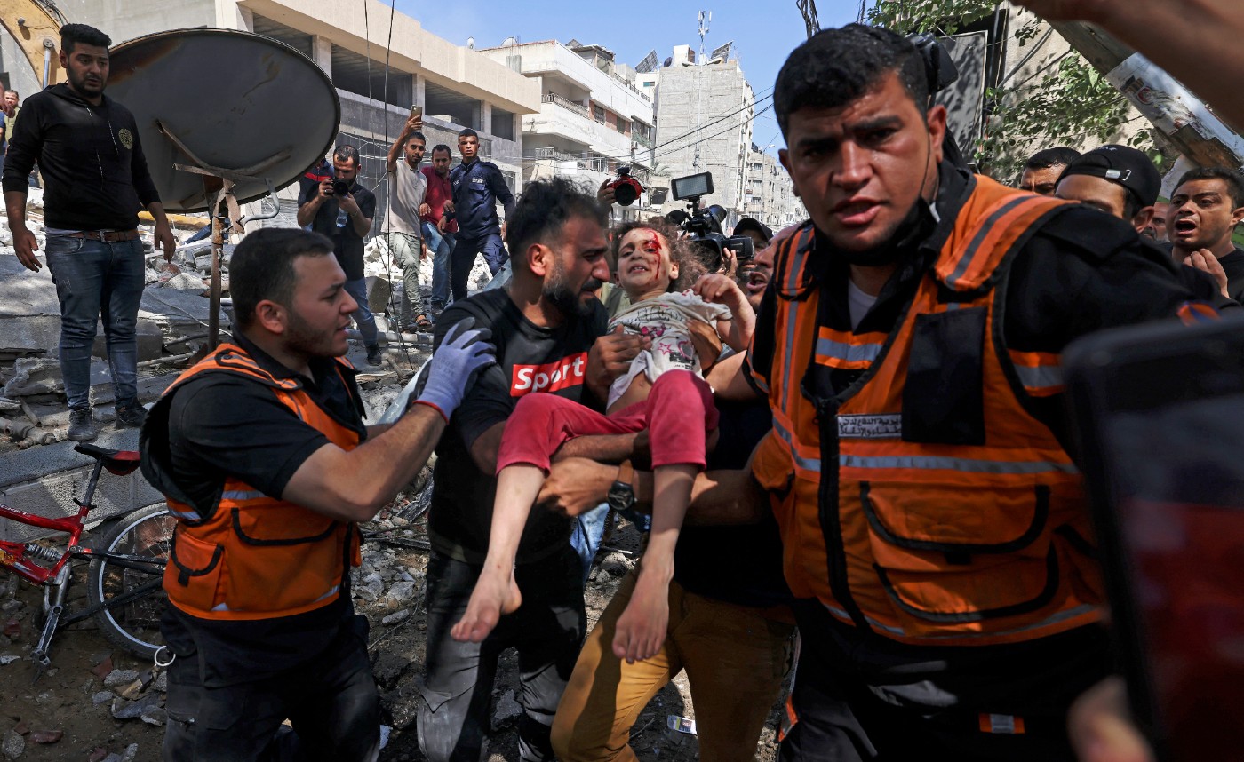 Palestinian Suzy Eshkuntana is carried pulled from the rubble in Gaza City's Rimal district on May 16, 2021, after an Israeli air strike killed the rest of her family apart from her father (AFP).