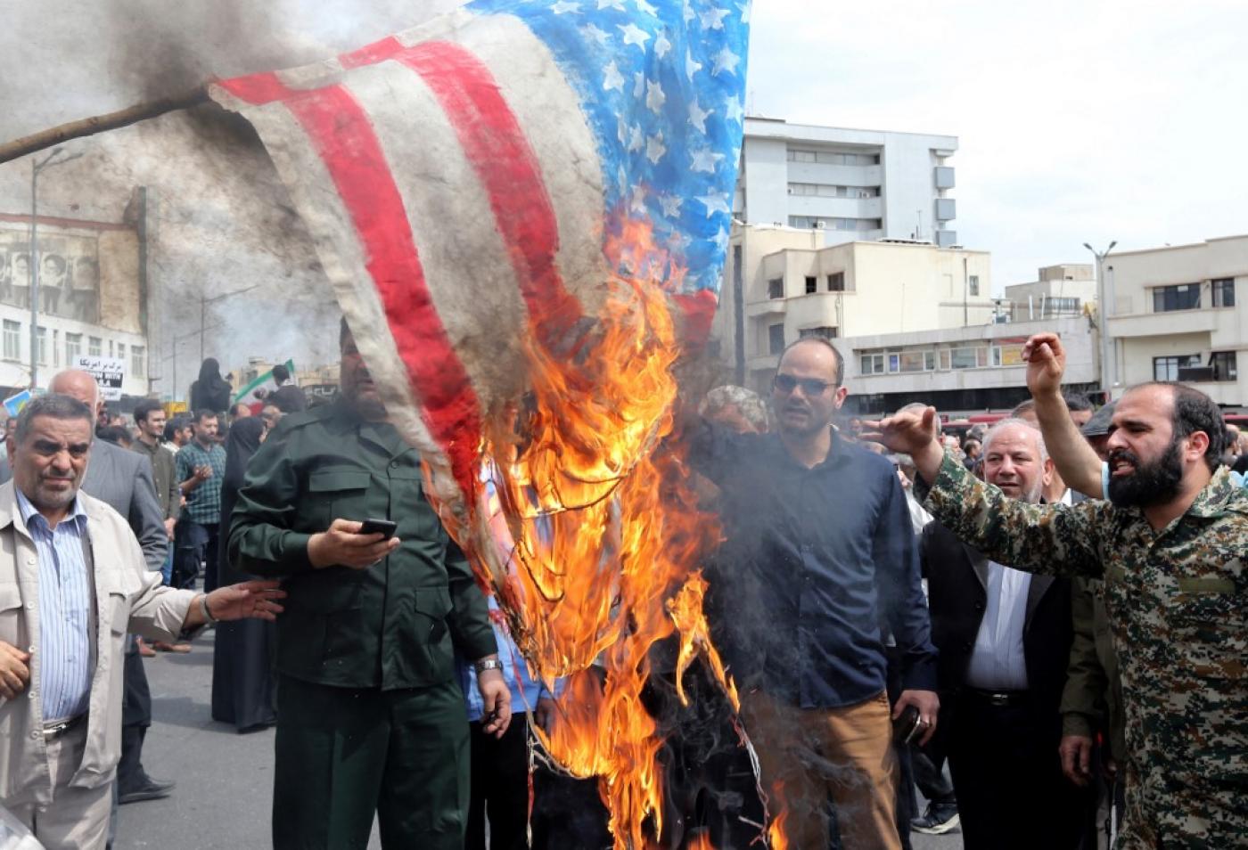 Iranians burn a US flag during a rally in Tehran on 12 April 2019 (AFP)