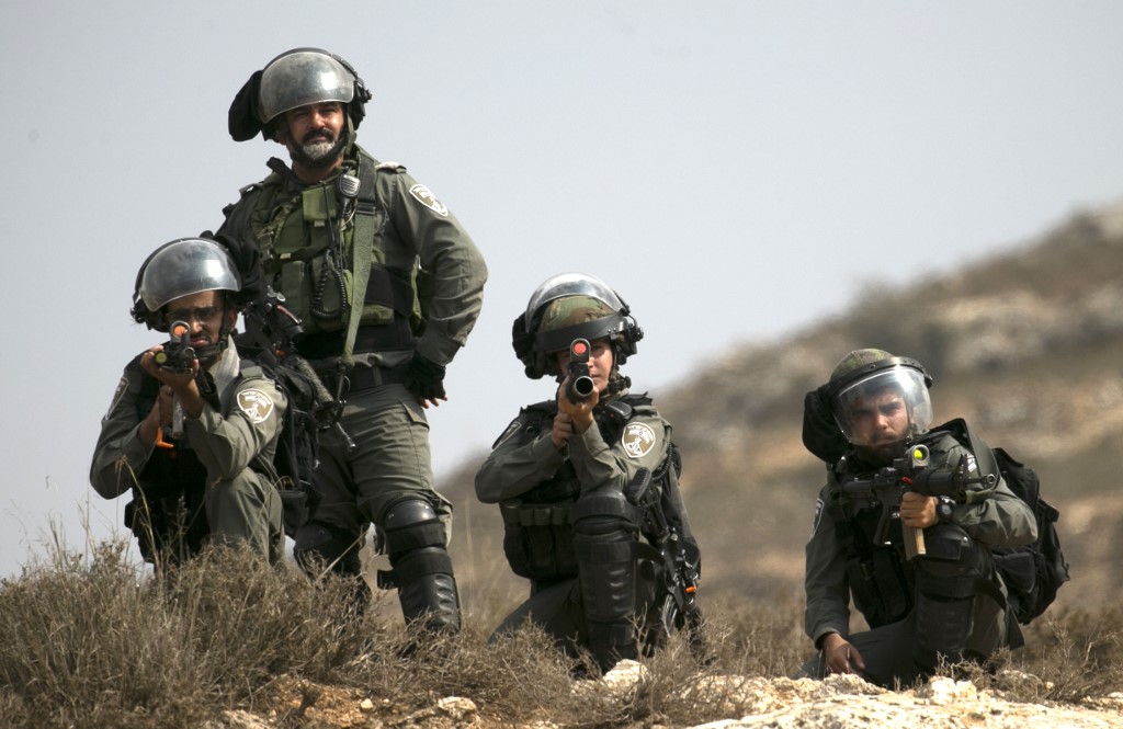 Israeli forces take aim during a protest by Palestinians near Ramallah on 17 October (AFP)