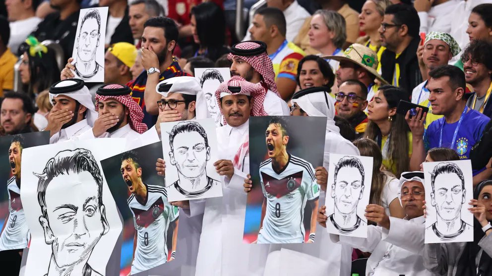 Qatari World Cup fans hold up portraits of Mesut Ozil, the German Turkish football player, in protest against western ‘double standards’ (Screengrab/Twitter)