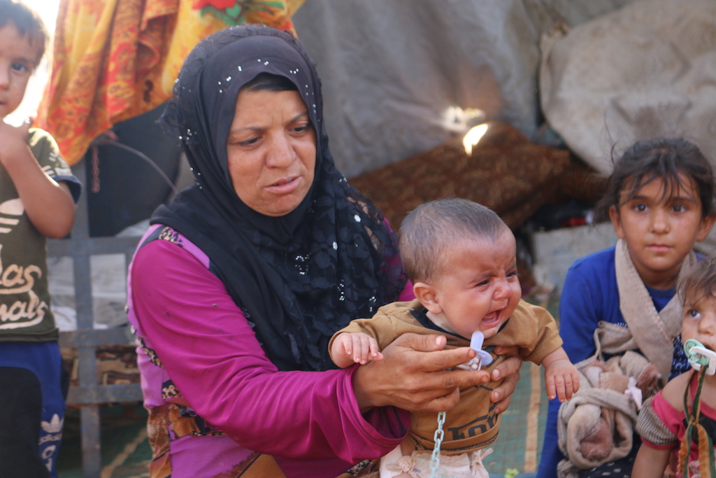 Une mère et son bébé dans le camp (MEE/Mustafa Dahnon)
