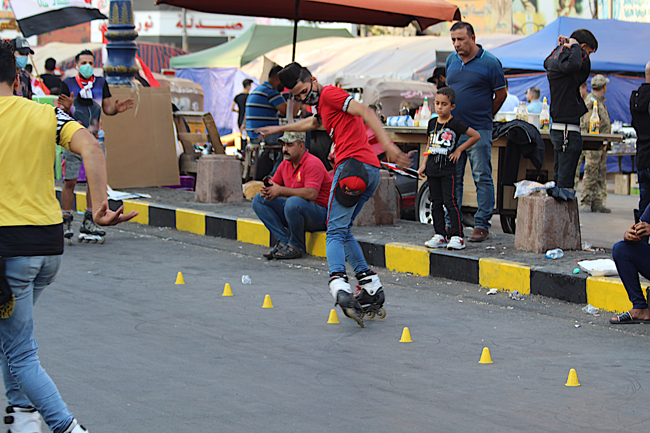 A young man skates between cones on Saadoun Street near Tahrir Square (MEE/Alex MacDonald)