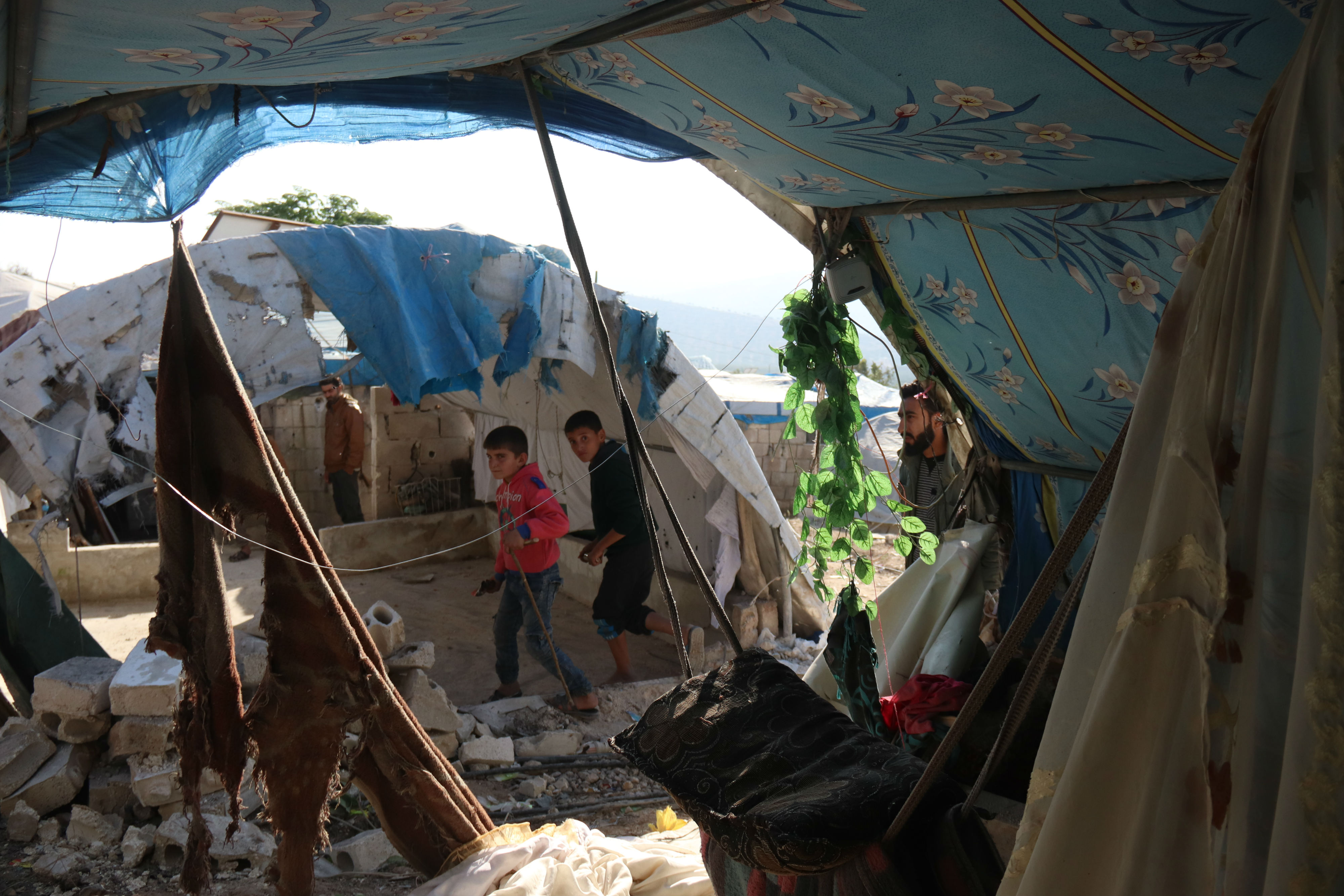 Children walk through the damaged camp in Syria's Qah (MEE/Muhammad Alhosy)