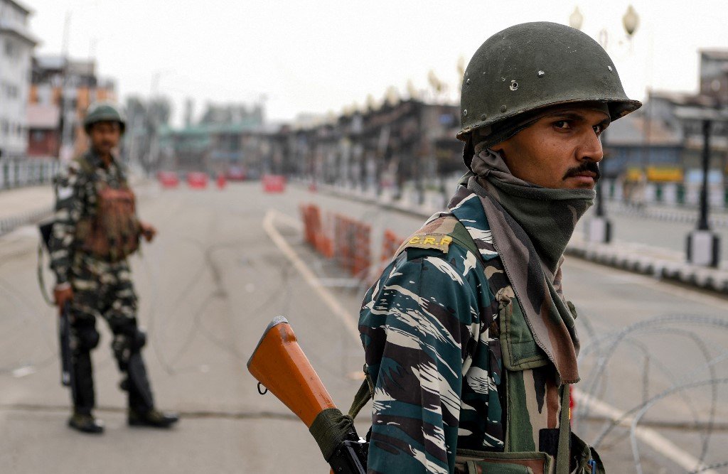 Des membres des forces de sécurité indiennes montent la garde sur une route déserte lors du couvre-feu imposé à Srinagar, en août 2019 (AFP)