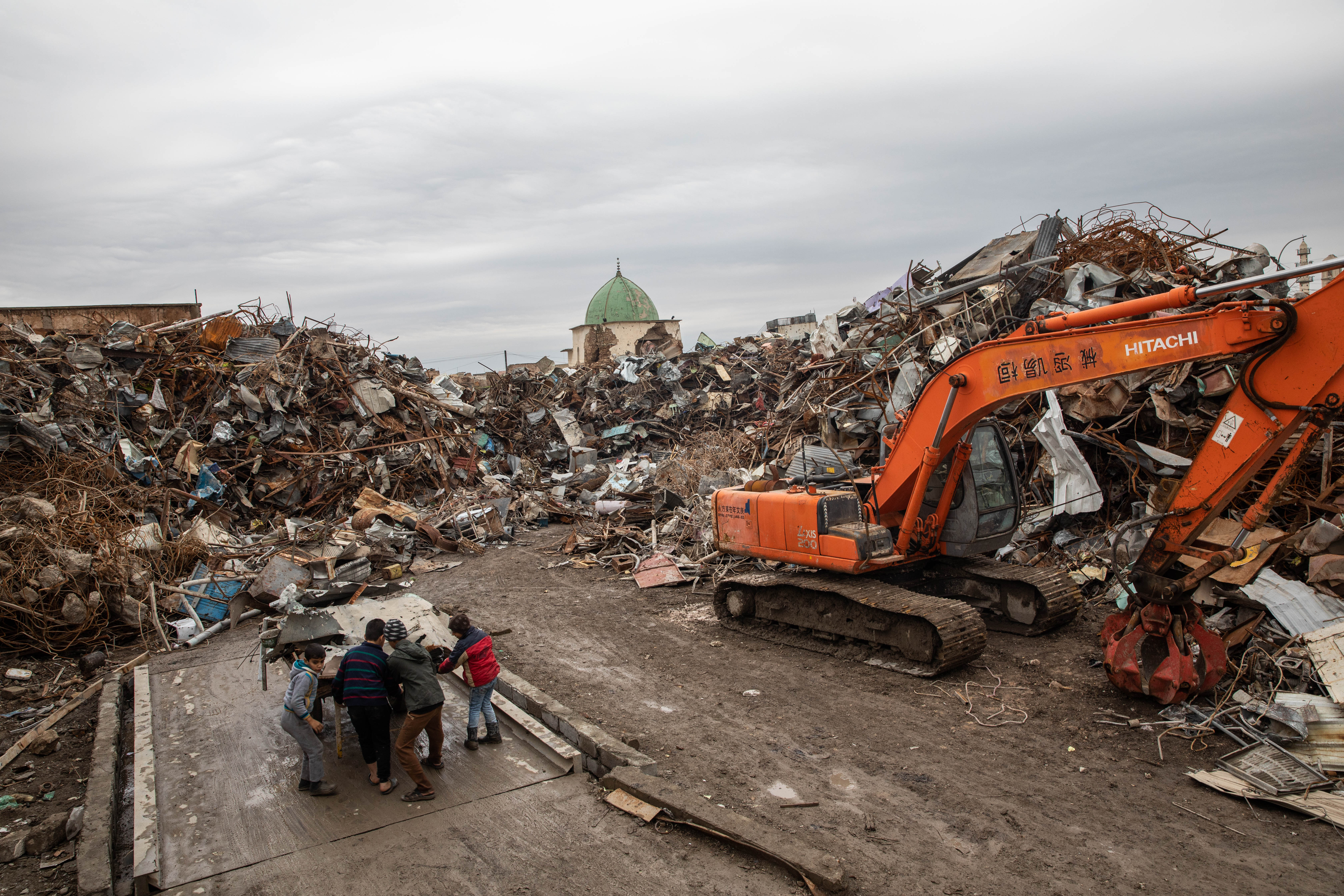 A scrapyard obscures a view of the ruins of the famous al-Nuri Mosque and its adjacent Hadba minaret (Tom Westcott/MEE)