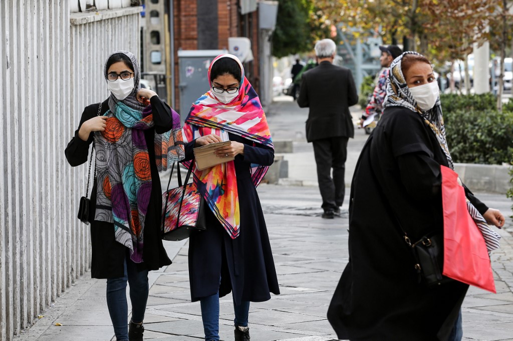 Women, mask-clad due to the COVID-19 coronavirus pandemic, walk along a street in Iran's capital Tehran on November 8, 2020.