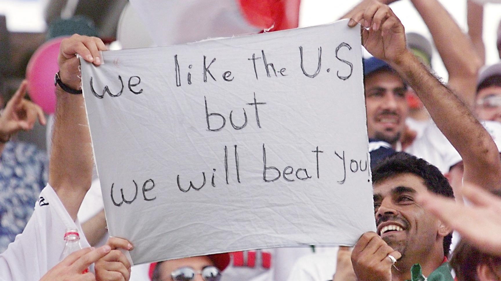 Iranian supporters display a placard reading: 'We like the USA but we will beat you' at the 1998 World Cup Group match between Iran and the United States on 21 June, 1998 (AFP)