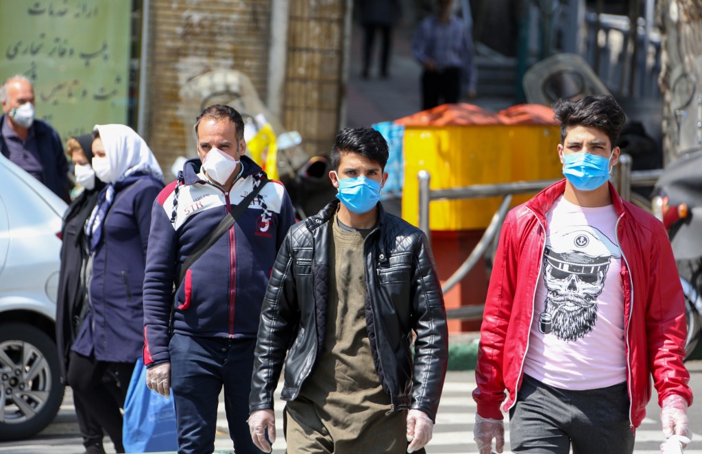 Iranians wear protective face masks in Tehran on 5 April (AFP)