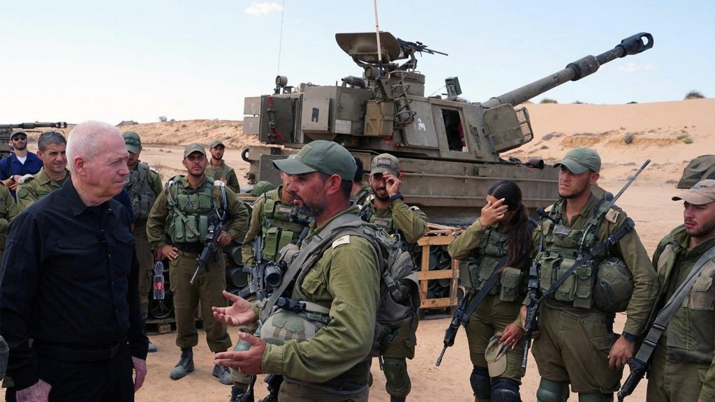 A picture released by the Israeli army on 7 May 2024 shows Defence Minister Yoav Gallant standing with soldiers at a position in southern Israel near Rafah, Gaza (Israeli Army/AFP)