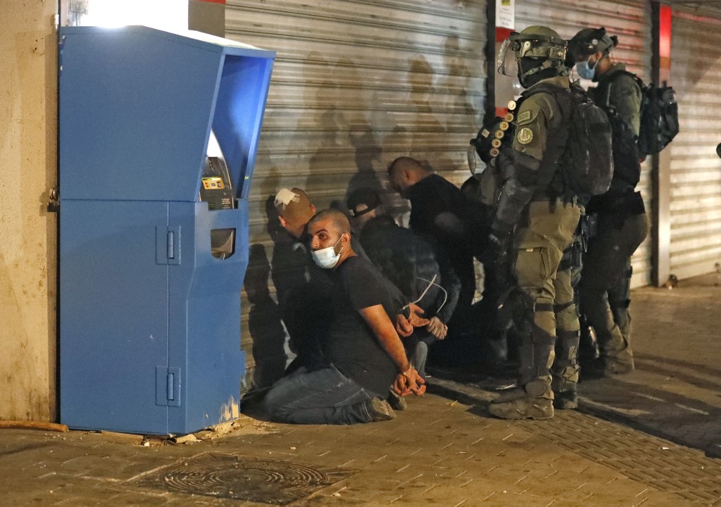 Israeli forces detain a group of Arab-Israelis in the mixed Jewish-Arab city of Lod on May 13, 2021, during clashes between Israeli far-right extremists and Arab-Israelis. Ahmad GHARABLI / AFP