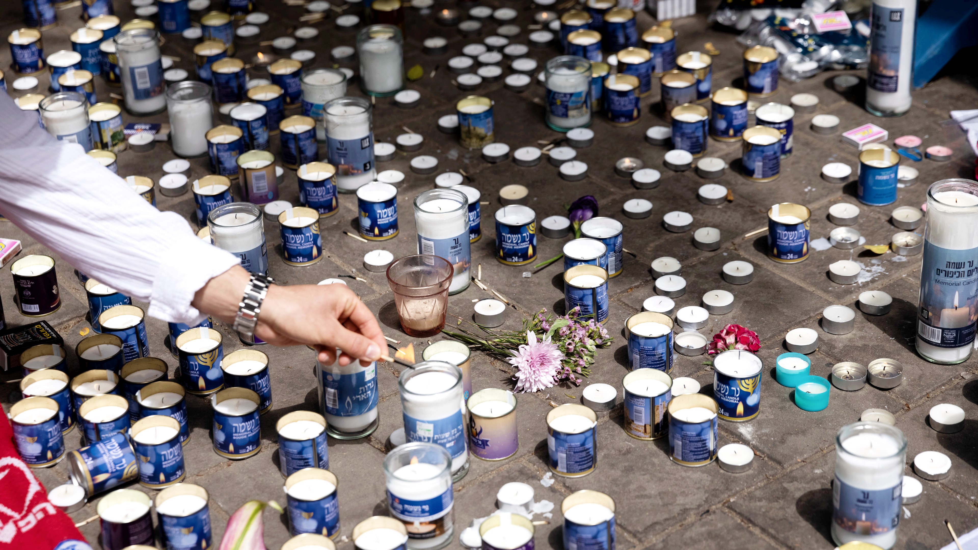 Israelis light candles to remember the victims of the shooting in Dizengoff Street in central Tel Aviv. (MEE/Oren Ziv)