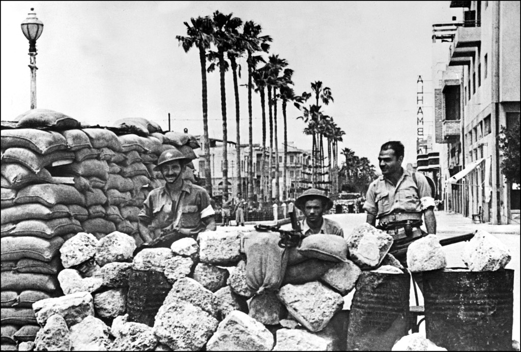 Jewish forces stand guard behind a barricade in Jaffa during fighting with Arab forces in 1948 (AFP)