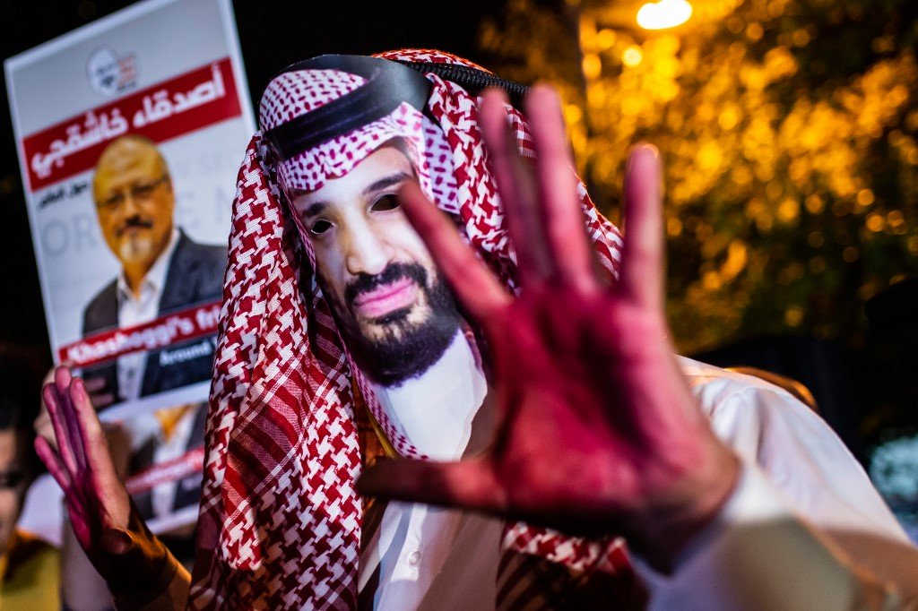 Un manifestant avec un masque du prince héritier saoudien Mohammed ben Salmane et les mains peintes en rouge lors d’un rassemblement de protestation suite au meurtre du journaliste Jamal Khashoggi en 2018 à Istanbul, en Turquie (AFP)