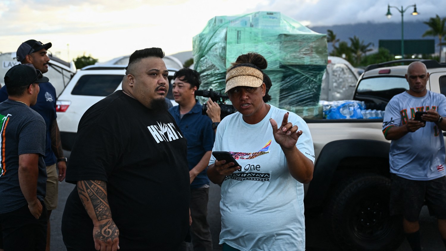 Volunteers Kale Kahele (L) and Kanani Adolpho help organise donations as volunteers load pallets of supplies and aid donations flown in from the Hawaiian island of Kauai at the Kahului airport cargo terminal in the aftermath Maui wildfires on 13 August 2023.