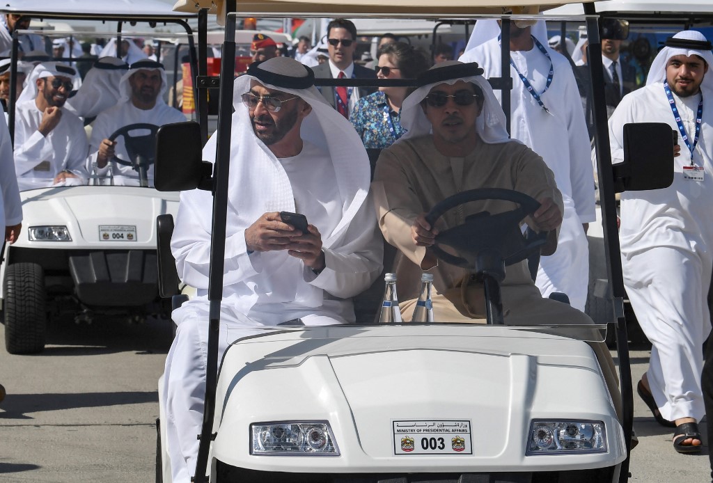 Mohammed bin Zayed sits with his brother, Mansour, at the Dubai airshow in November 2019 (AFP)