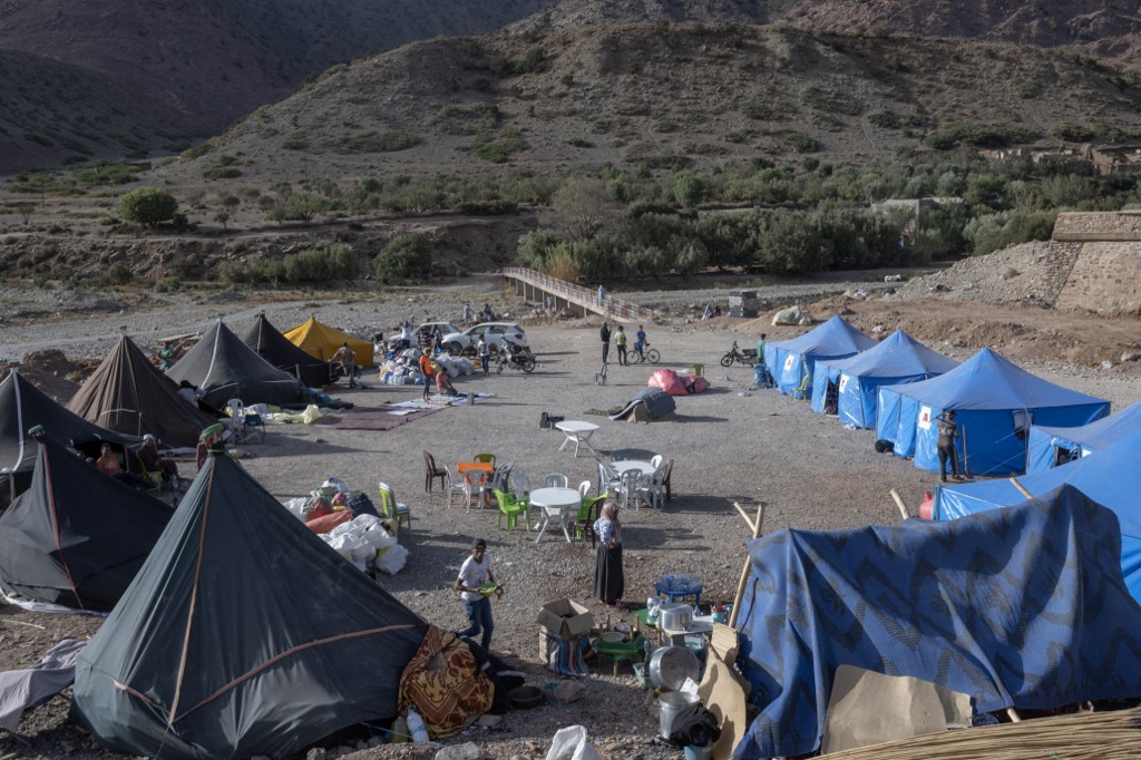 Displaced people gather in a camp in the Atlas Mountains range between Maarakesh and Taroudant, on 14 September 2023 (AFP)