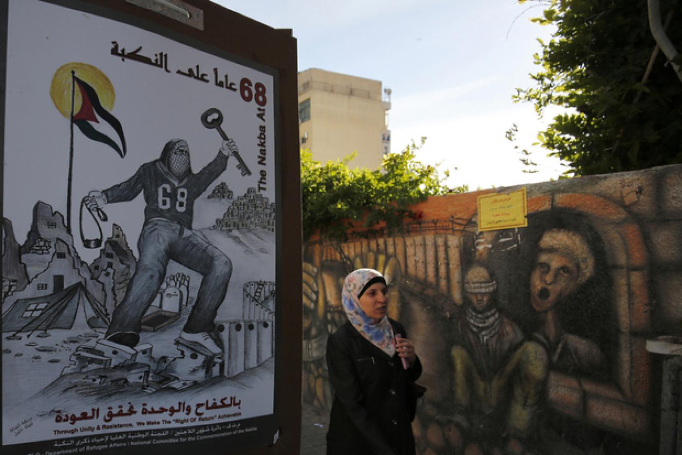 Une Palestinienne passe à côté d’une affiche représentant une clé qui symbolise les clés des maisons laissées par les Palestiniens en 1948, le 11 mai 2016, à Ramallah (Cisjordanie occupée) (AFP)