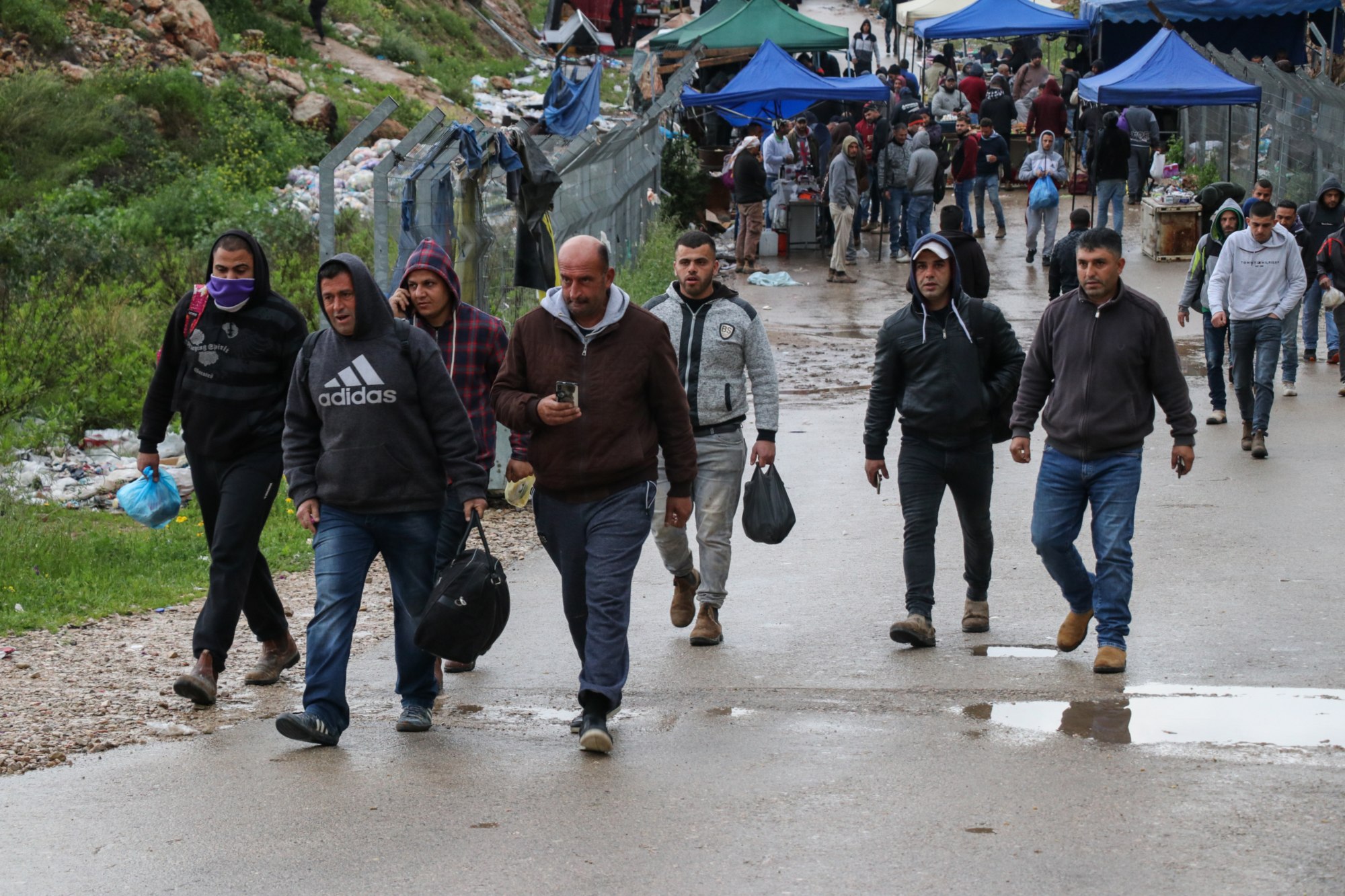 Des travailleurs palestiniens se rendent au check-point de Nilin le 18 mars, alors qu’Israël leur a exceptionnellement permis de passer la nuit dans le pays (MEE/Mohammad Abu Zaid)