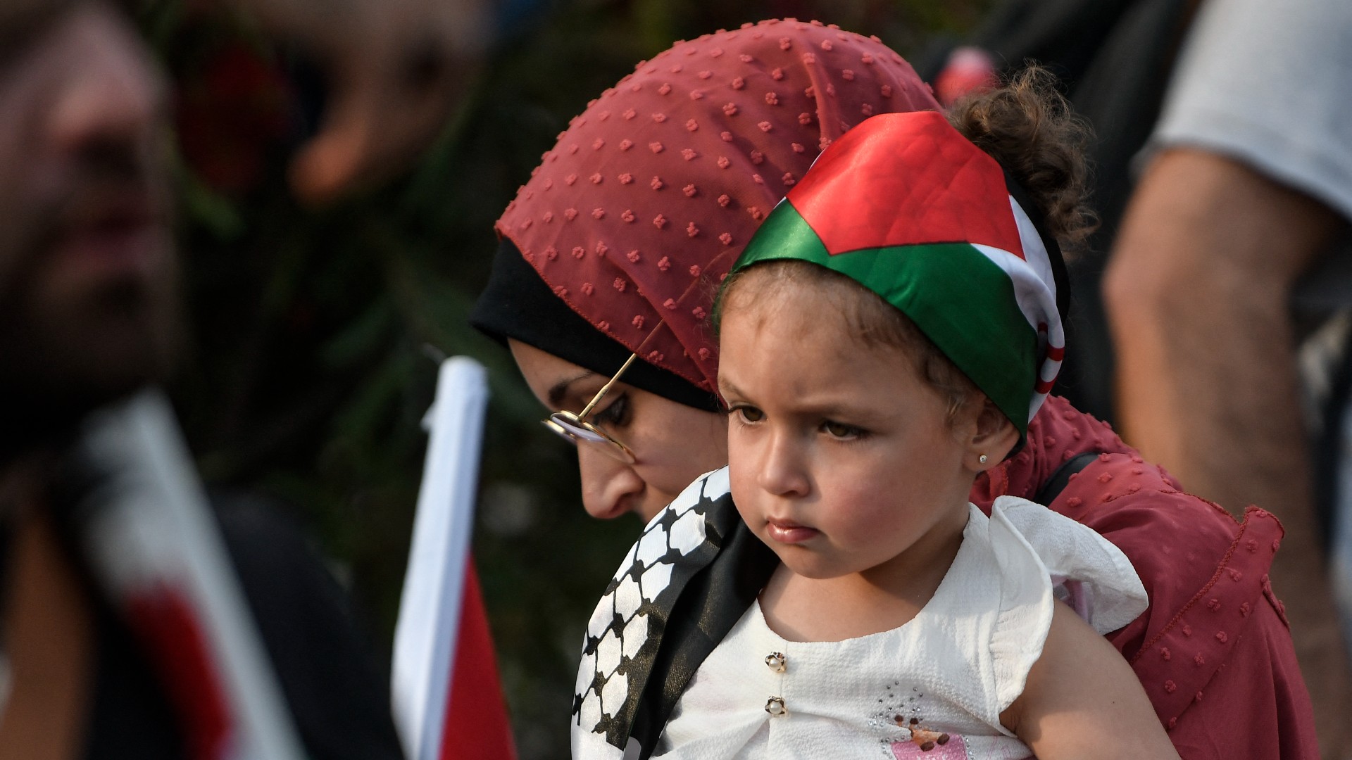 A mother and her child are pictured as protesters take part in a demonstration in front of the Israeli embassy to support Palestinians after Al Jazeera reporter Shireen Abu Akleh was killed, in Athens on May 16, 2022.