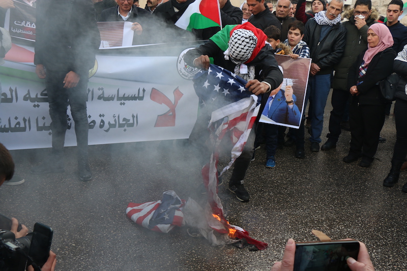 Palestinian protestor in Bethlehem burns American flag (MEE/Akram al Waarah)