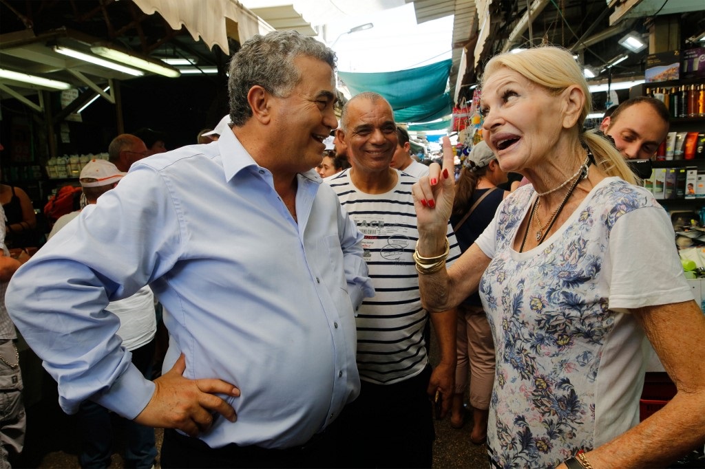 Labor leader Amir Peretz speaks with people in Tel Aviv's Carmel market (AFP) 